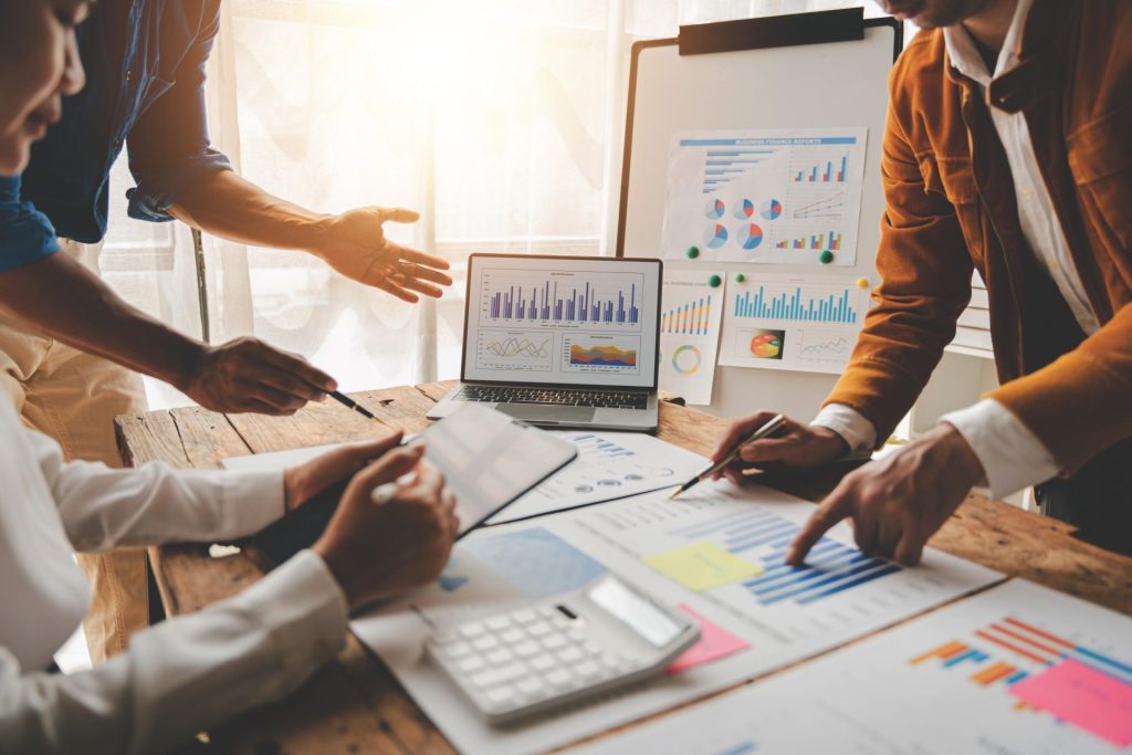 Group of accountants working together on documents, charts, and laptop